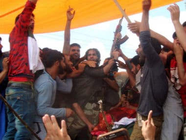 A militant offers gun-salute at the funeral of Suhail Ahmad Tantray in a village in Kulgam. Image courtesy: Hilal Shah