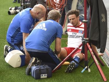 In this Aug. 19, 2017 photo Hamburg's Nicolai Mueller is treated during the German Bundesliga soccer match between Hamburger SV and FC Augsburg in Hamburg, Germany. Hamburger SV forward Nicolai Mueller is out for around six months after injuring himself while celebrating a goal. The Bundesliga club says Mueller tore a cruciate ligament in his right knee after scoring in Saturday's league-opener, a 1-0 home win over Augsburg. Mueller attempted a pirouette before falling to the ground in apparent pain. (Daniel Bockwoldt/dpa via AP)