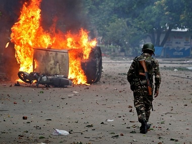 File image of a member of the security forces walking towards a burning vehicles during violence in Panchkula, India, August 25, 2017.