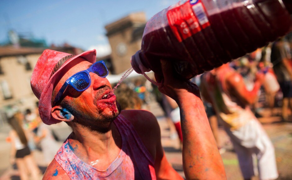 Revelers drink red wine, throw coloured powder at each other and dance to the tunes of Bollywood songs at the festival. AP Revelers drink red wine, throw coloured powder at each other and dance to the tunes of Bollywood songs at the festival. AP