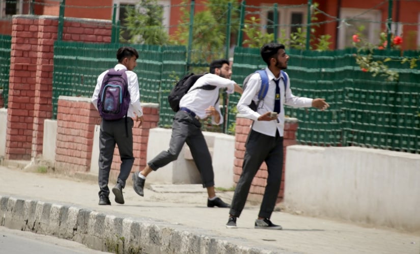 A student throws a rock at the security forces during clashes in Srinagar. Firstpost/Suhail Bhat