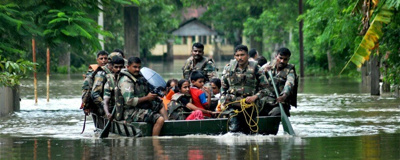 NDRF personnel rescue people affected by flash floods in Assam on Monday. PTI