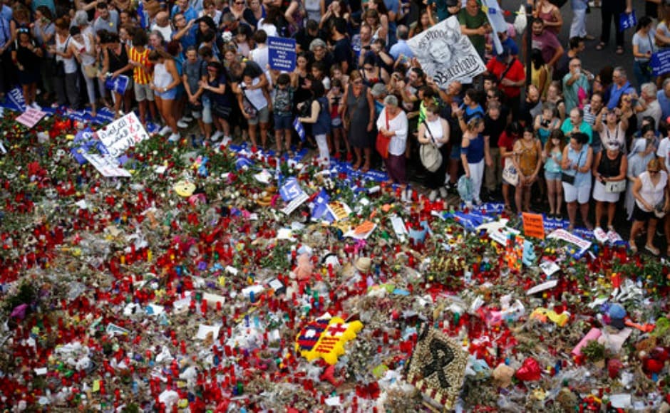 People gather next to candles and flowers placed on the ground in Las Ramblas following the demonstration. The slogan of the demonstration was People gather next to candles and flowers placed on the ground in Las Ramblas following the demonstration. The slogan of the demonstration was