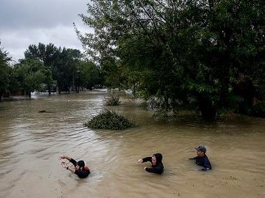 People wade through chest deep water due to constant rain from Hurricane Harvey. AP