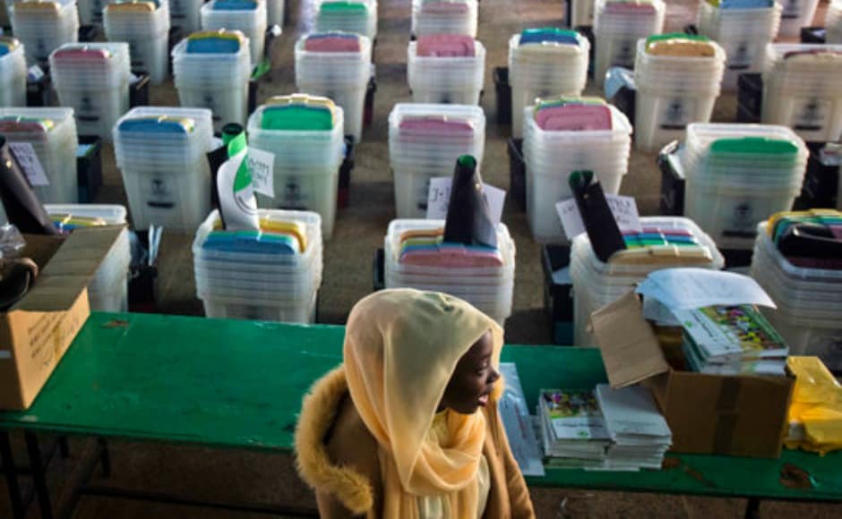 A Kenyan election volunteer walks past ballot boxes and electoral material to be distributed to various polling stations in Nairobi, Kenya, Monday, Aug. 7, 2017. Kenyans are due to go to the polls on Aug. 8. to vote in a general election after a tightly-fought presidential race between President Uhuru Kenyatta and main opposition leader Raila Odinga. (AP Photo/Jerome Delay)