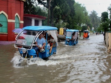Vehicles ply through a waterlogged road after heavy rains at Balurghat in South Dinajpur district of West Bengal on Sunday. PTI