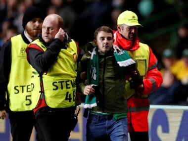 Celtic fan is removed by stewards after invading the pitch. Reuters