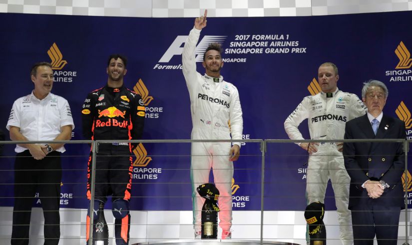 Mercedes' Lewis Hamilton celebrates winning the race on the podium with Red Bull's Daniel Ricciardo and teammate Valtteri Bottas. Reuters