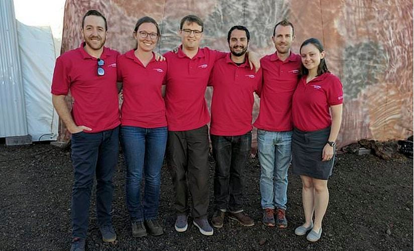 University of Hawaii shows the university's Hawaii Space Exploration Analog and Simulation (HI-SEAS) crew members, from left, Joshua Ehrlich, Mission Specialist, Biology, Laura Lark, Mission Specialist, Information Technology and Outreach, Samuel Payler, Science Officer, Brian Ramos, Health and Performance Officer, James Bevington, Commander, and Ansley Barnard, Engineering Officer outside the HI-SEAS facility at the Mauna Loa volcano, Big Island, Hawaii. Image: Associated Press