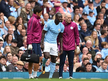 Manchester City's French defender Benjamin Mendy (C) is helped by medics during the English Premier League football match between Manchester City and Crystal Palace at the Etihad Stadium in Manchester, north west England, on September 23, 2017. / AFP PHOTO / Oli SCARFF / RESTRICTED TO EDITORIAL USE. No use with unauthorized audio, video, data, fixture lists, club/league logos or 'live' services. Online in-match use limited to 75 images, no video emulation. No use in betting, games or single club/league/player publications. /