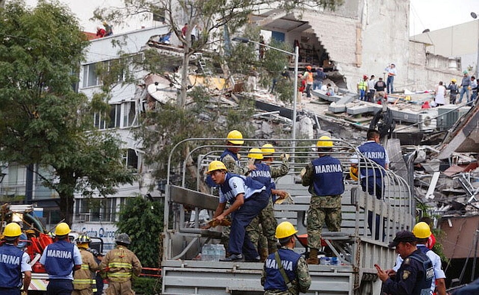 In several locations, large crowds of people clambered on buildings that were now piles of stone and tangled metal, trying to pull people out. Emergency workers held up signs commanding In several locations, large crowds of people clambered on buildings that were now piles of stone and tangled metal, trying to pull people out. Emergency workers held up signs commanding