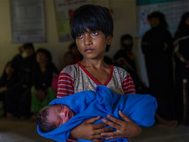 Rohingya Muslim girl Afeefa Bebi holds her few-hours-old brother at a community hospital in Kutupalong refugee camp, Bangladesh. AP