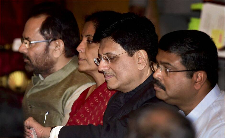 Cabinet Minister Piyush Goyal checks time in his wrist watch as he waits with cabinet colleagues Nirmala Sitharaman, Mukhtar Abbas Naqvi and Dharmendra Pradhan for the swearing in ceremony at Rashtrapati Bhavan in New Delhi on Sunday. PTI