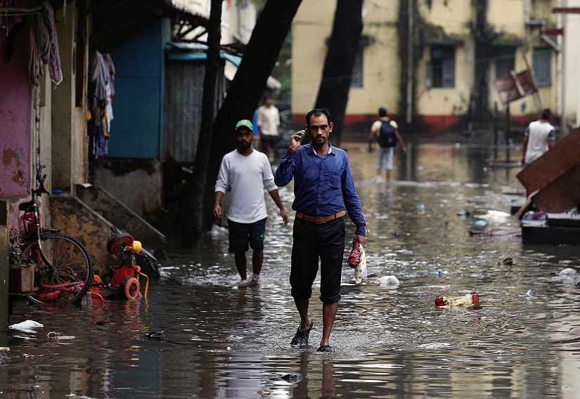 People walk through a partially flooded street at a residential area in Mumbai, India, August 30, 2017. REUTERS