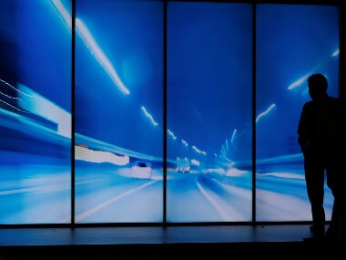 A man stands in fron of the huge Sharp flat screens at the IFA Electronics show in Berlin, Germany August 31, 2017. REUTERS/Hannibal Hanschke