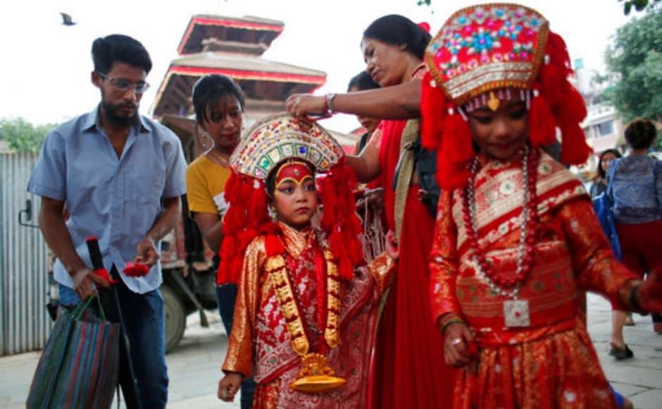 A Nepalese woman gets her daughter ready for Kumari Puja. The festival is held to commemorate the victory over a demon named Tundi. AP A Nepalese woman gets her daughter ready for Kumari Puja. The festival is held to commemorate the victory over a demon named Tundi. AP