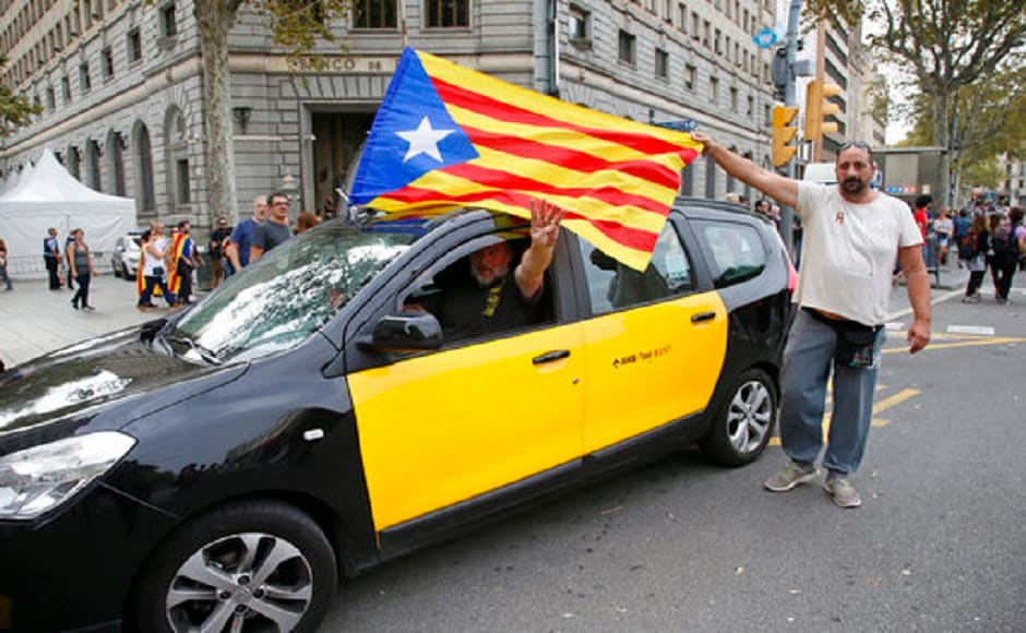 A taxi driver with an ''estelada'' or Catalonia independence flag fixed to his car, gestures as a protester helps to extend the flag during the protest near the national police headquarters during a one-day strike in Barcelona, Spain. AP A taxi driver with an ''estelada'' or Catalonia independence flag fixed to his car, gestures as a protester helps to extend the flag during the protest near the national police headquarters during a one-day strike in Barcelona, Spain. AP