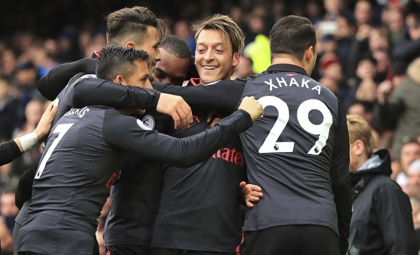 Arsenal's Mesut Ozil, center, celebrates scoring his side's second goal against Everton. AP