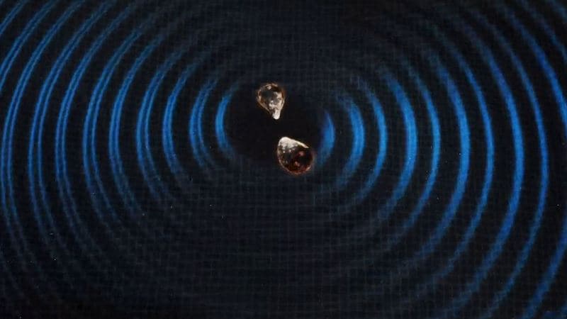 Two neutron stars merge sending a ripple og gravitational waves through space and time. Image Courtesy: Kilonova 