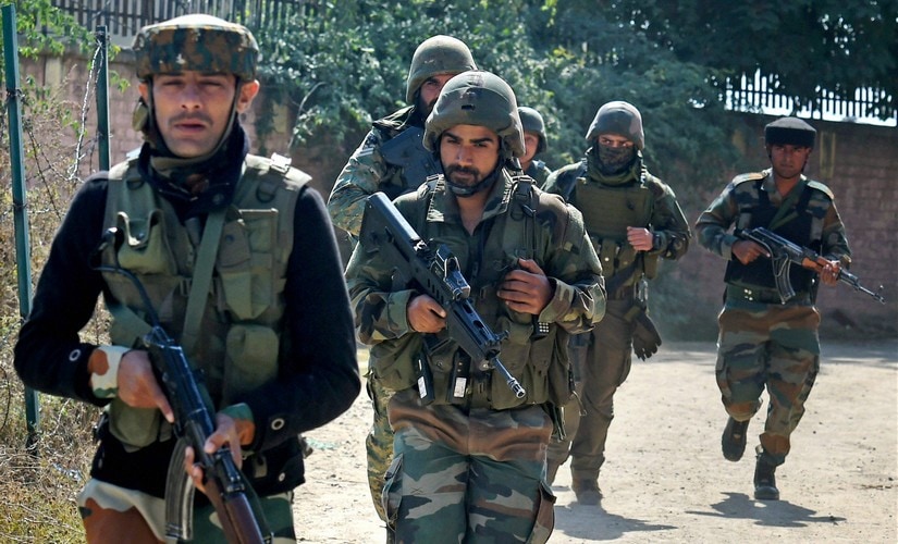 Security personnel run to take positions during an encounter with militants who stormed a BSF camp near the Srinagar International Airport on Tuesday. PTI