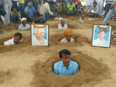 Zameen Samadhi Satyagraha: Why scores of farmers in a Rajasthan village are burying themselves in neck-deep pits Zameen Samadhi Satyagraha: Why scores of farmers in a Rajasthan village are burying themselves in neck-deep pits