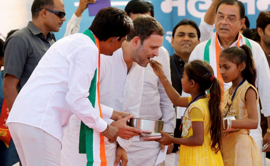 Congress vice-president Rahul Gandhi being offered sweets by children during a public meeting in Gandhinagar, Gujarat on Monday. OBC leader Alpesh Thakor, who joined the party at the rally, is also seen. PTI Congress vice-president Rahul Gandhi being offered sweets by children during a public meeting in Gandhinagar, Gujarat on Monday. OBC leader Alpesh Thakor, who joined the party at the rally, is also seen. PTI