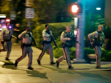 Police run to cover at the scene of the shooting in Las Vegas. AP
