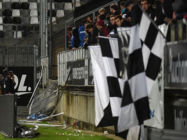 Members of the stadium staff stand by the stadium barrier that collapsed during the French L1 football match between Amiens and Lille LOSC on September 30, 2017 at the Licorne stadium in Amiens. Several Lille supporters were hurt in Amiens when a stadium barrier collapsed in the away section as the visiting fans celebrated the opening goal of the match. The Ligue 1 fixture was interrupted in the 16th minute after LOSC French defender Fode Ballo-Toure's goal sparked celebrations that caused a fence separating the fans from the pitch to crumble under their weight. / AFP PHOTO / FRANCOIS LO PRESTI