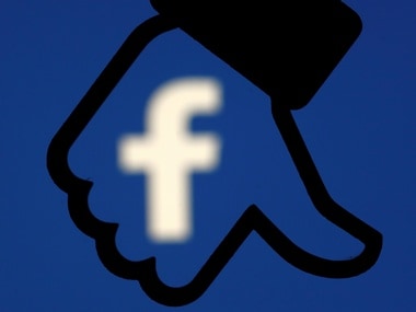 A 3D-printed Facebook dislike button is seen in front the Facebook logo. Image: Reuters.