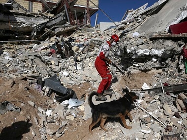 A rescue worker searches the debris on the earthquake site. AP