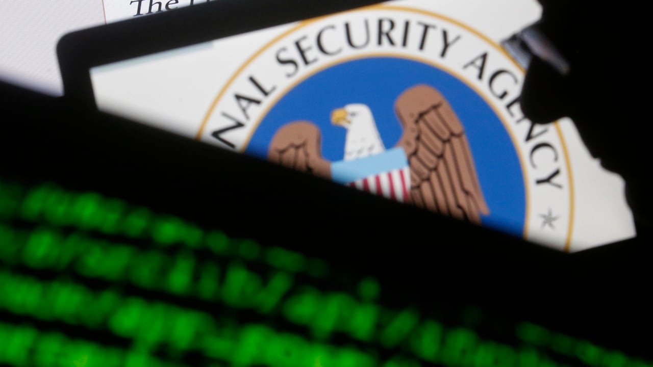 A man is seen near cyber code and the US National Security Agency logo. Reuters.