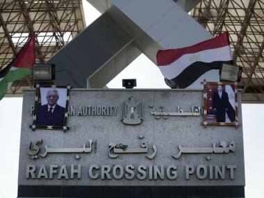 Palestinian and Egyptian flags wave over two photos of Palestinian President, Mahmoud Abbas, and Egypt’s President Abdel-Fattah el-Sissi, hanging on the main gate of the Rafah crossing border. AP