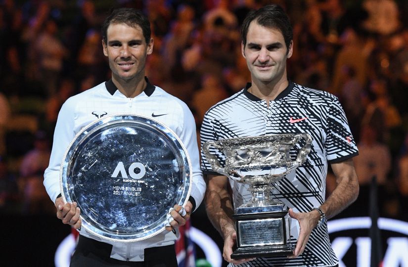 File photo of Roger Federer with the championship trophy during the awards ceremony after his victory against Rafael Nadal in the men's singles final of the Australian Open. AFP