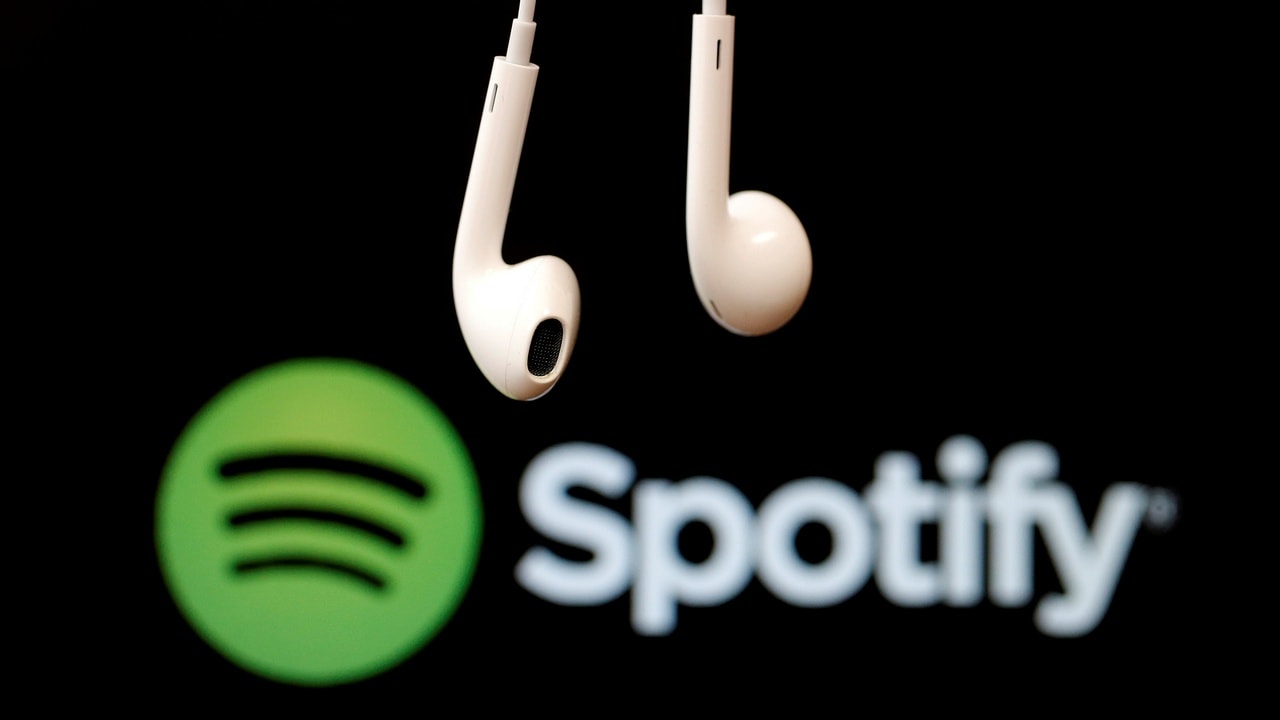 Headphones are seen in front of a logo of online music streaming service Spotify in this February 18, 2014 illustration picture. REUTERS/Christian Hartmann/File Photo - D1BETHKCBRAA