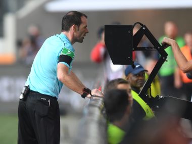 Referee Marco Fritz checking the Video Assistant Referee (VAR) during a Bundesliga match between FC Augsburg and Borussia Dortmund. AFP