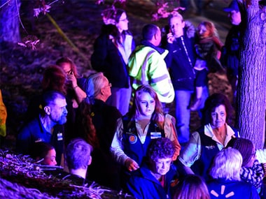 Walmart employees gather together outside away from the scene of the shooting. AP