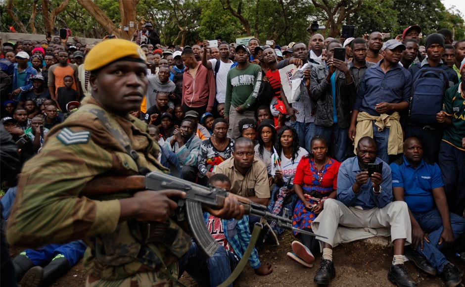 An army soldier stands guard of the crowd. Mugabe, the only ruler Zimbabwe has known since independence from Britain in 1980, has been holed up in his lavish ‘Blue Roof’ compound, from where he has watched support from his Zanu-PF party, the security services and the people evaporate in the wake of a military seizure of power on Wednesday. AP An army soldier stands guard of the crowd. Mugabe, the only ruler Zimbabwe has known since independence from Britain in 1980, has been holed up in his lavish ‘Blue Roof’ compound, from where he has watched support from his Zanu-PF party, the security services and the people evaporate in the wake of a military seizure of power on Wednesday. AP