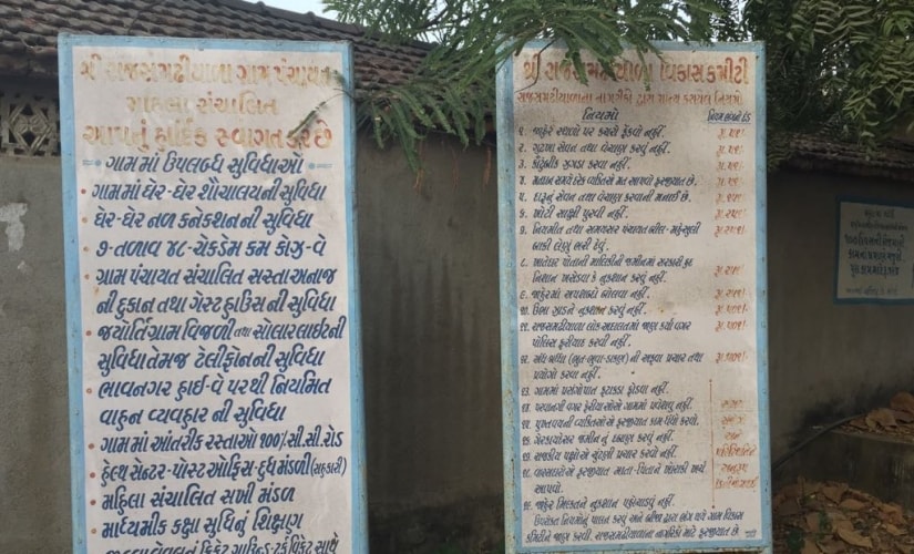 The two boards listing the rules and facilities in Rajsamadiyala village. Firstpost/Amitesh Singh