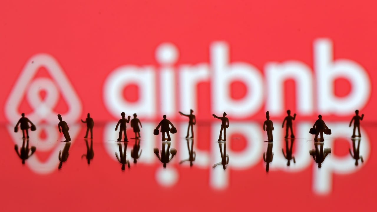 A 3D printed people's models displayed in front of Airbnb logo. Image: Reuters
