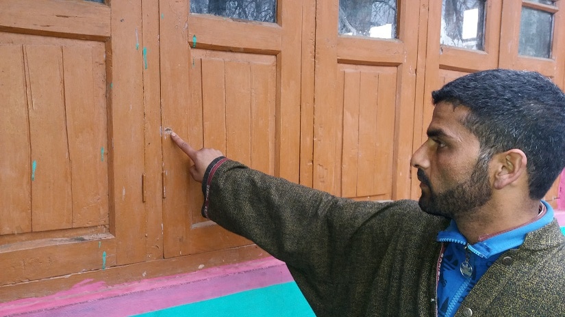 Mohammad Yakooq Bhat, the younger brother of Jan, showing the bullet mark on the window. Firstpost/Sameer Yasir