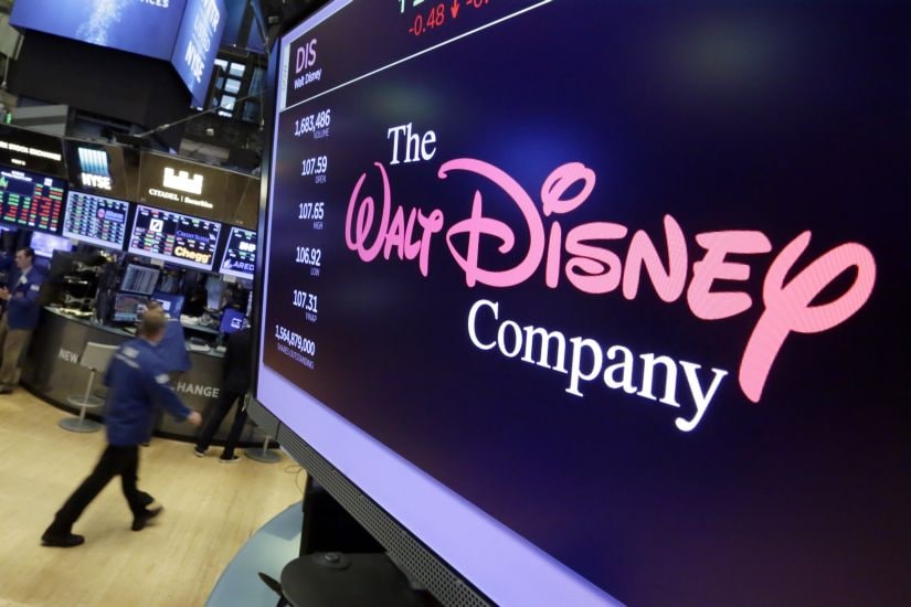 FILE - In this Aug. 8, 2017, file photo, The Walt Disney Co. logo appears on a screen above the floor of the New York Stock Exchange. Disney is buying a large part of the Murdoch family's 21st Century Fox in a $52.4 billion deal, announced Thursday, Dec. 14, including film and television studios, cable and international TV businesses as it tries to meet competition from technology companies in the entertainment business. (AP Photo/Richard Drew, File)