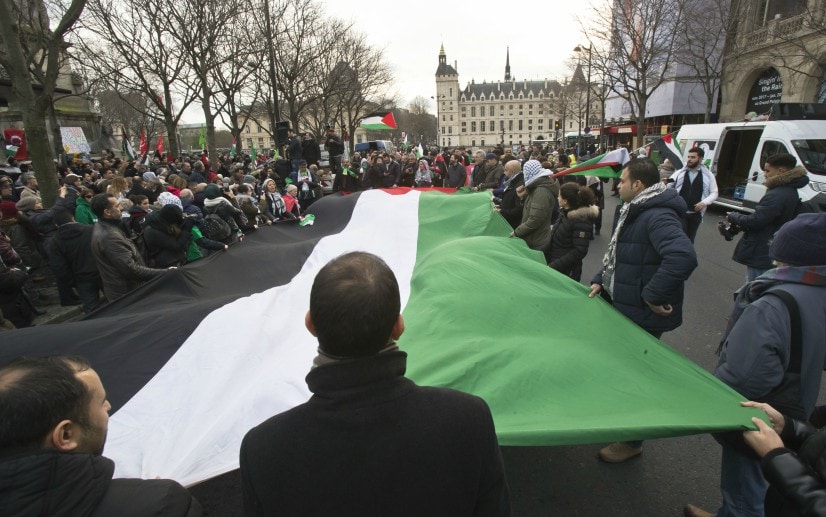 Demonstrators hold a Palestinian flag as they stage a protest against US president Donald Trump's decision to recognise Jerusalem as the capital of Israel in Paris. AP