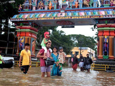 People wade through a flooded street in Suchindram at flood-hit Kanyakumari district on Friday. PTI