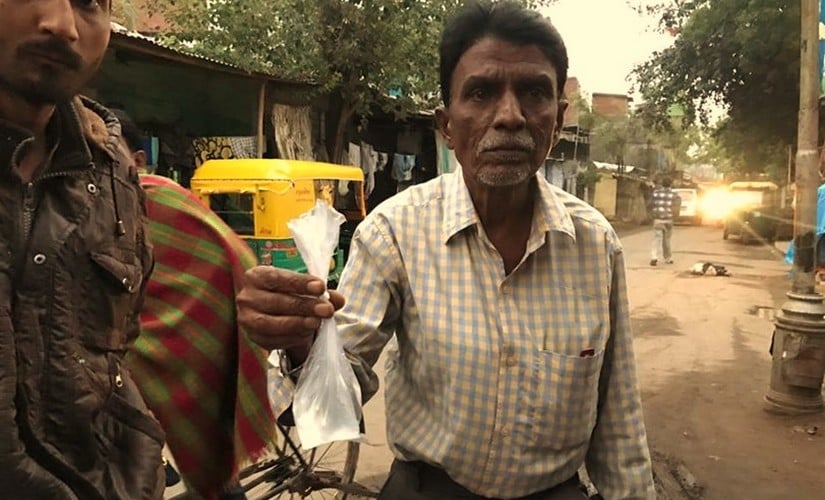 Mahesh Sukhadia holds out a packet of cheap chemical liquor that costs Rs 10. His 45-year-old brother recently died of alcohol abuse in the Dalit-dominated Gomtipur. Pallavi Rebbapragada/Firstpost
