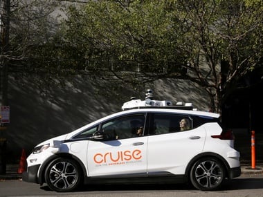 A woman smiles in the back seat of a self-driving Chevy Bolt . Reuters