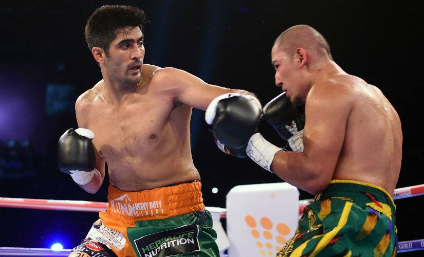 Vijender Singh (L) throws a punch at Zulpikar Maimaitiali during their double WBO title bout in Mumbai on 5 August, 2017. AFP
