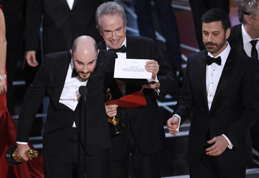 FILE - In this Feb. 26, 2017, file photo, Jordan Horowitz, producer of "La La Land," left, shows the envelope revealing "Moonlight" as the true winner of best picture at the Oscars in Los Angeles as presenter Warren Beatty and host Jimmy Kimmel, right, look on. The film academy and its accounting firm, PwC, are announcing a spate of new rules Monday, Jan. 22, 2018, meant to avoid an envelope gaffe like at last year’s show, when “La La Land” was mistakenly announced as the winner instead of “Moonlight.” PwC U.S. Chairman Tim Ryan said the new protocols include additional personnel and oversight, as well as practicing what to do if a presenter reads the wrong name. (Photo by Chris Pizzello/Invision/AP, File)