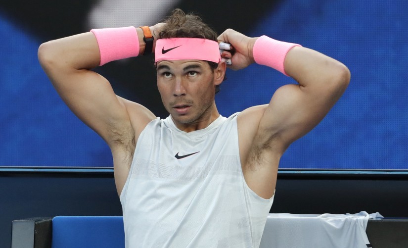 Rafael Nadal ties his headband during a break while playing Victor Estrella Burgos during their first round match at the Australian Open. AP