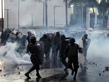 Military police stand amid tear gas as they clash with supporters of opposition presidential candidate Salvador Nasralla near the presidential house in Tegucigalpa, Honduras, Friday, Jan. 12, 2018. AP