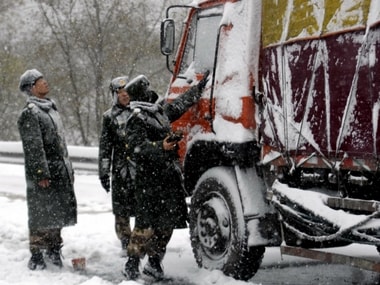 rescuers checking a stranded truck that was caught in a traffic jam on Badaling highway in the suburb of Beijing during an unusually early snowstorm. AFP